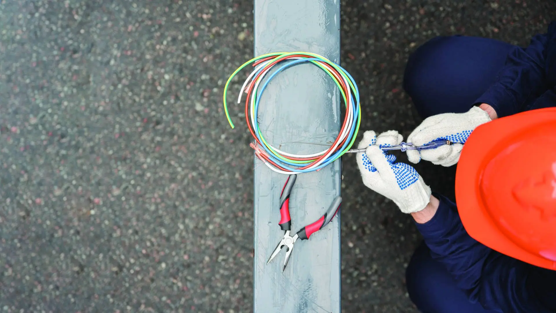 Elektrik kablolarında koruyucu eldivenle çalışan teknisyen