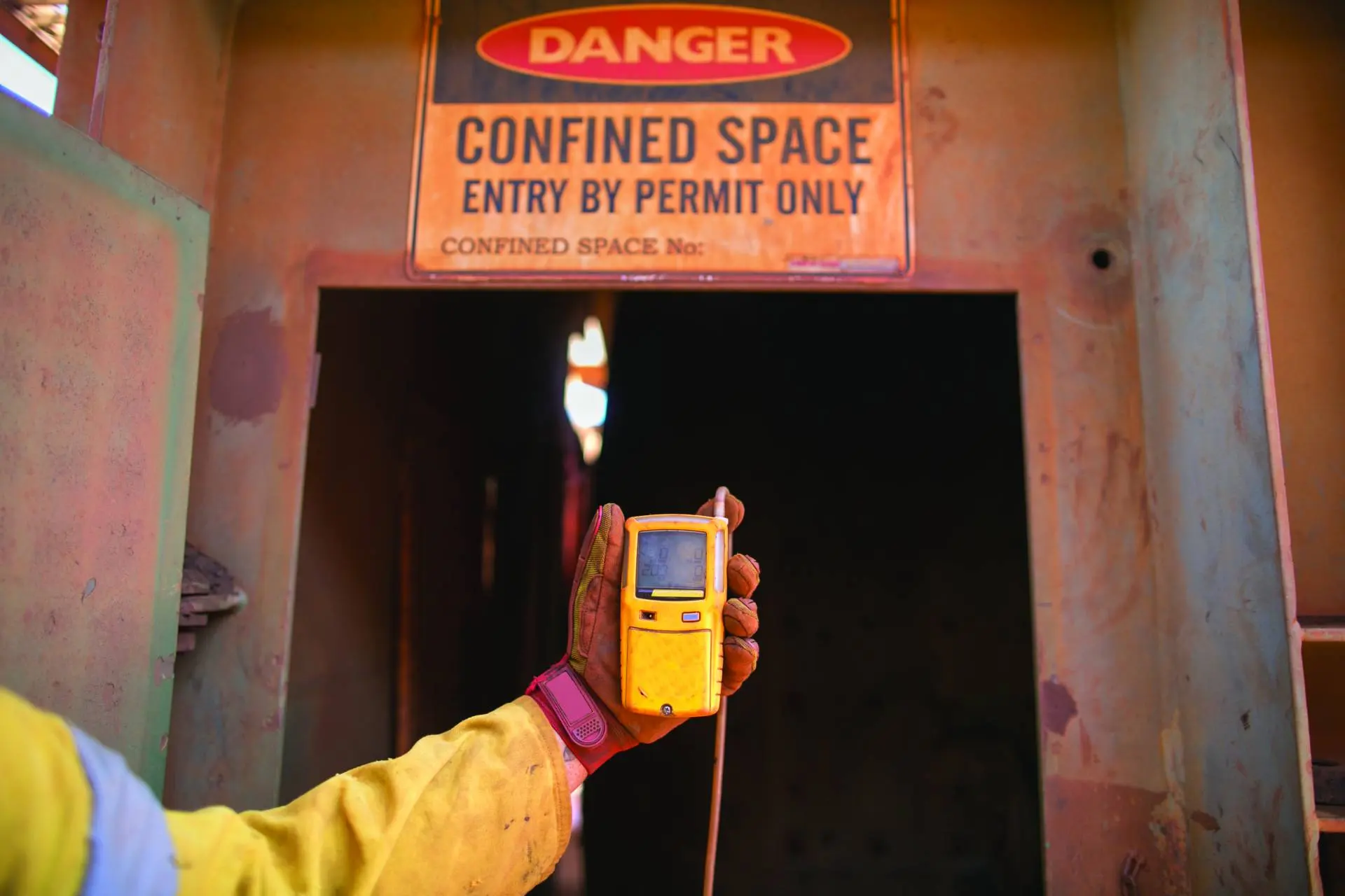 Gaz ölçüm cihazıyla 'Confined Space – Entry by Permit Only' uyarılı girişte çalışan teknisyen