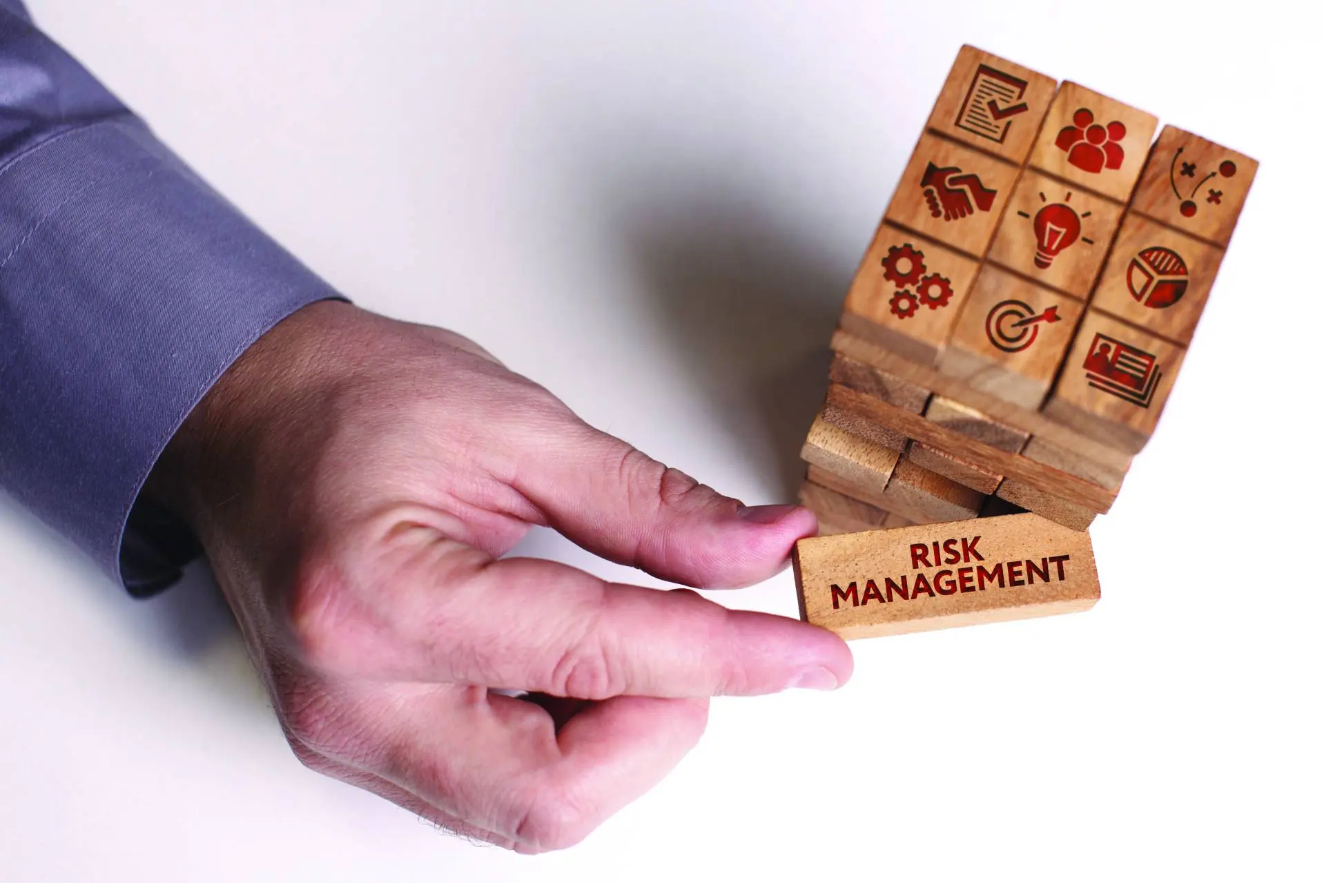 Elde tutulan "risk management" yazılı ahşap küp