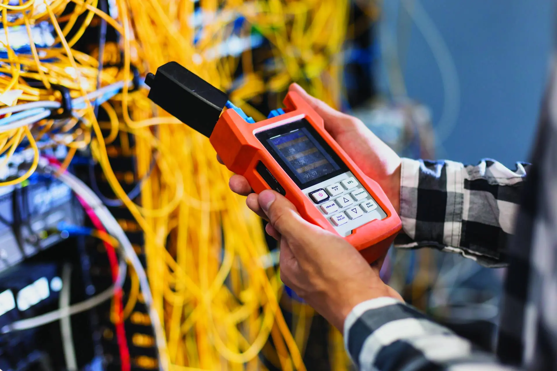 Elektrik panosunda ölçüm cihazıyla çalışan teknisyenin eli